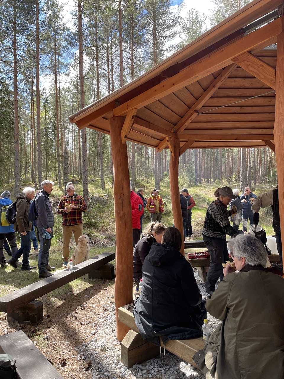 Deltagare som äter lunch och minglar tillsammans. Vissa sitter ner i grillhuset och vissa står upp.