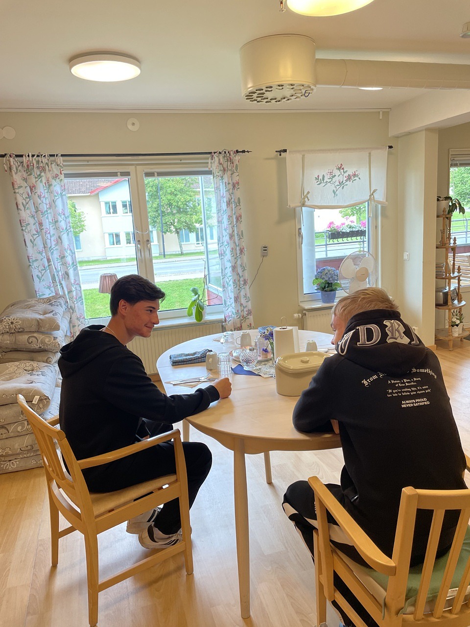 Gabriel och Lucas sitter vid ett bord och pratar.