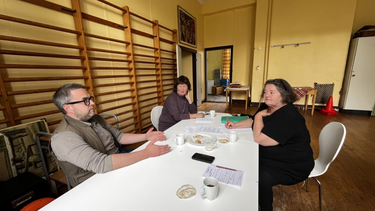 Andreas, sektor samhällsskydd och beredskap, Skinnskattebergs kommun i dialog med Monika och Gunilla från Baggbrons Byalag. De sitter vid ett avlångt, vitt bord.