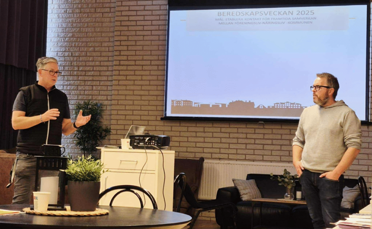 Tomas och Andreas från sektor Samhällsskydd och beredskap, Skinnskattebergs kommun, står framför en vit duk och pratar med deltagarna. De ser koncentrerade ut och Tomas gestikulerar med händerna.